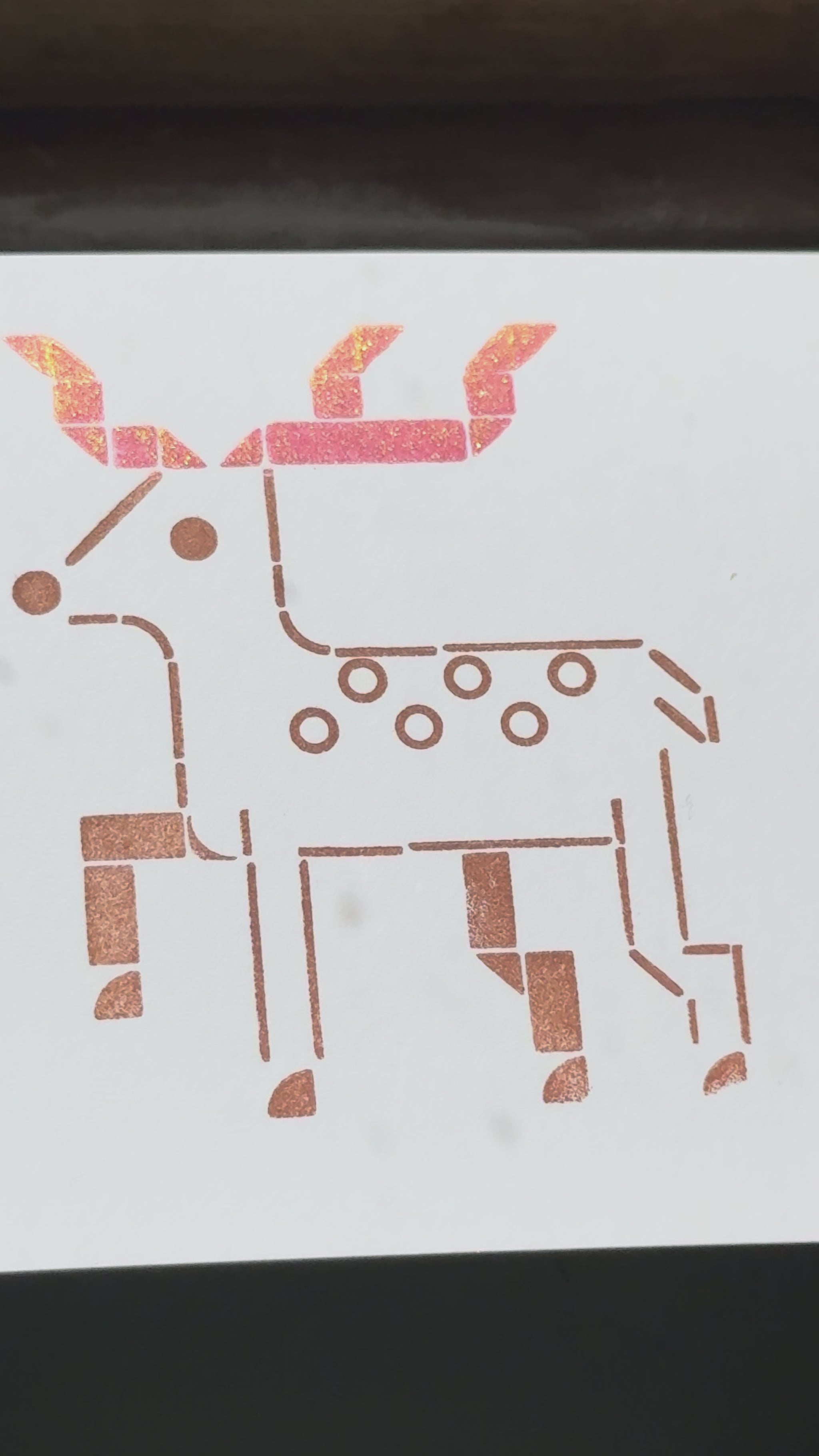 Print of a deer on a piece of white cardstock using Tsukineko Brilliance Rocket Red Gold and Coffee Bean ink colors