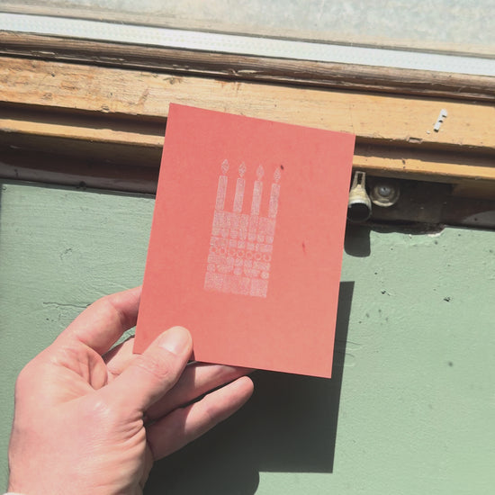 Print of a birthday cake on a piece of orange cardstock using Tsukineko Brilliance Platinum Planet ink