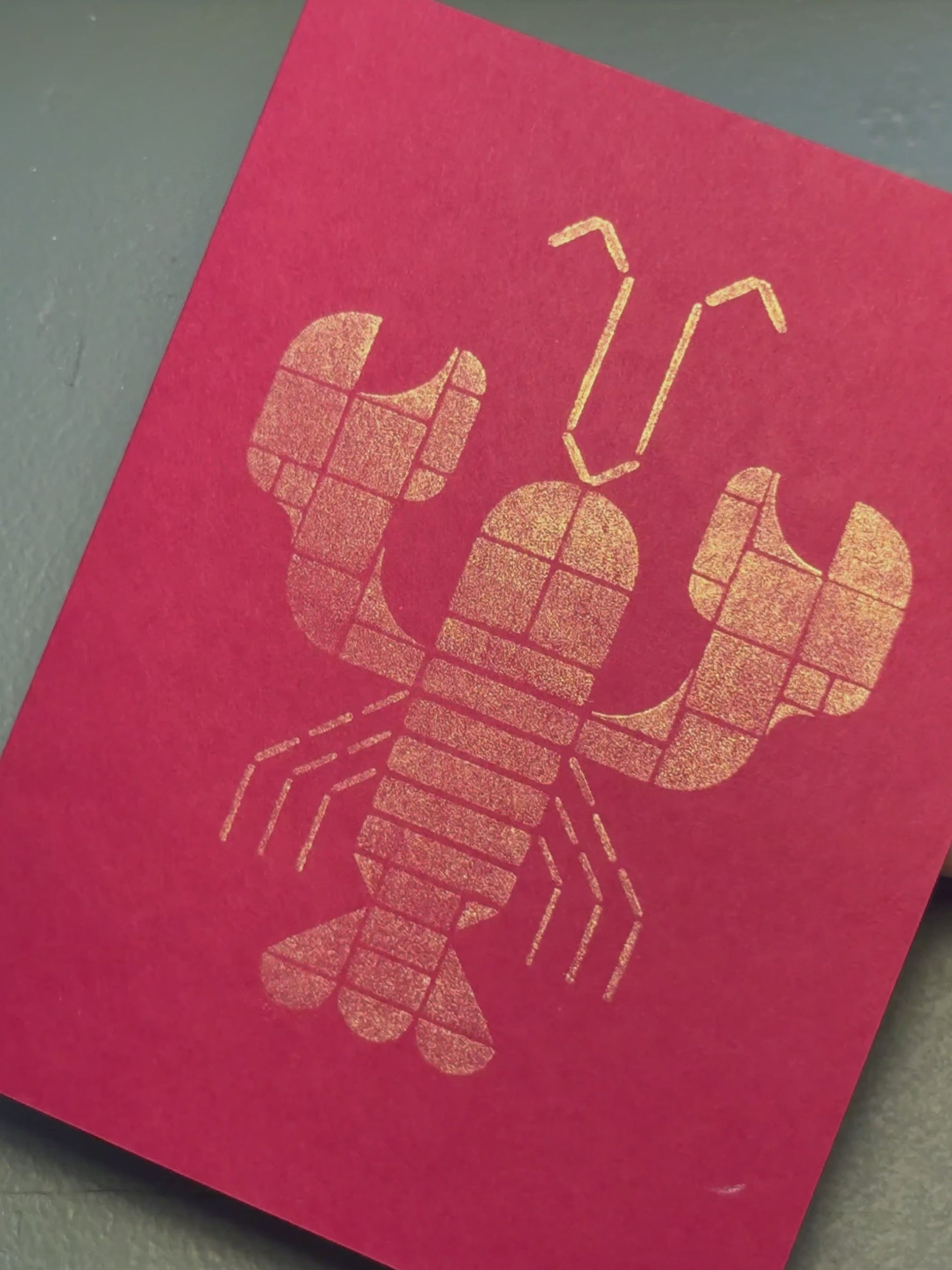Print of a lobster on a piece of red cardstock using Tsukineko Brilliance Galaxy Gold ink